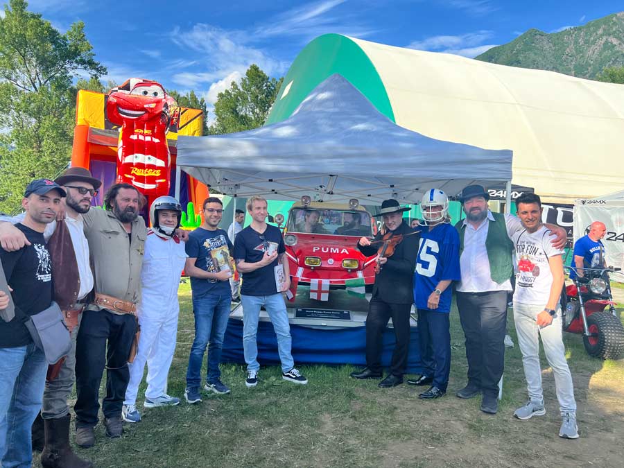 Foto di gruppo di persone con alle spallo la macchina dune buggy