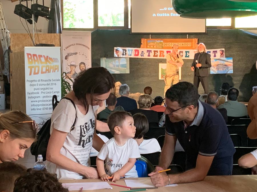 Mamma con bambino segue un corso di disegno con un disegnatore